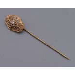 A vintage unmarked gold and diamond stick pin in a box. 5 cm high.