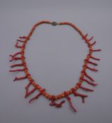 A red coral bead and twig coral necklace with silver clasp. 51 cm long.