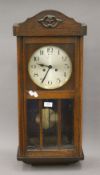 An early 20th century oak wall clock. 77 cm high.