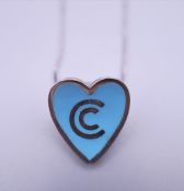 A silver enamel heart shaped pendant/brooch on chain.