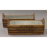 A pair of wooden boxes, inscribed 'Harrod's'. 34.5 cm long.