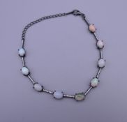 A black lacquered silver bracelet set with cabochon opals, moonstones and white stones. 21 cm long.