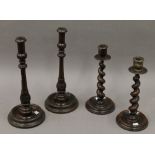 A pair of oak barley twist candlesticks and a pair of stained beech candlesticks.