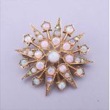 A 9 ct gold opal set starburst form pendant/brooch. 2.75 cm wide. 5.4 grammes total weight.