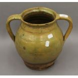 A 19th century glazed pottery twin handled vessel. 27 cm high.