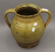 A 19th century glazed pottery twin handled vessel. 27 cm high.