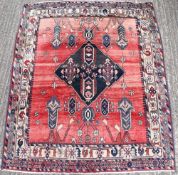 A red ground wool rug. 146 x 180 cm.