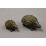 Two small bronze hedgehogs. The largest 5 cm long.