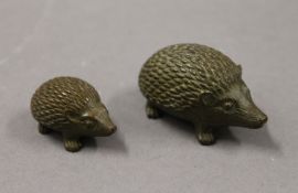 Two small bronze hedgehogs. The largest 5 cm long.