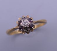 An 18 ct gold diamond and garnet ring. Ring size P.