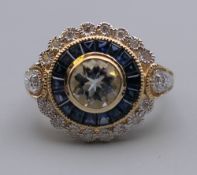 A 9 ct gold aquamarine, sapphire and diamond target ring. Ring size N.