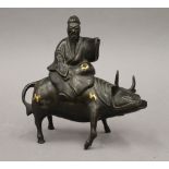 A Chinese bronze censer formed as a man sitting on a cow. 18 cm high.