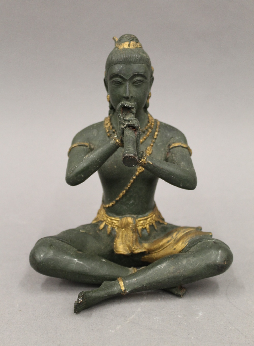 A bronze model of Buddha playing a flute. 18.5 cm high.