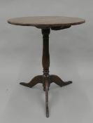 A Georgian oak tilt top tripod table. 57.5 cm diameter.