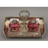 A silver plated desk stand set with cranberry glass inkwells. 28.5 cm wide.