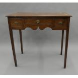 A George III oak three-drawer side table. 81.5 cm wide.