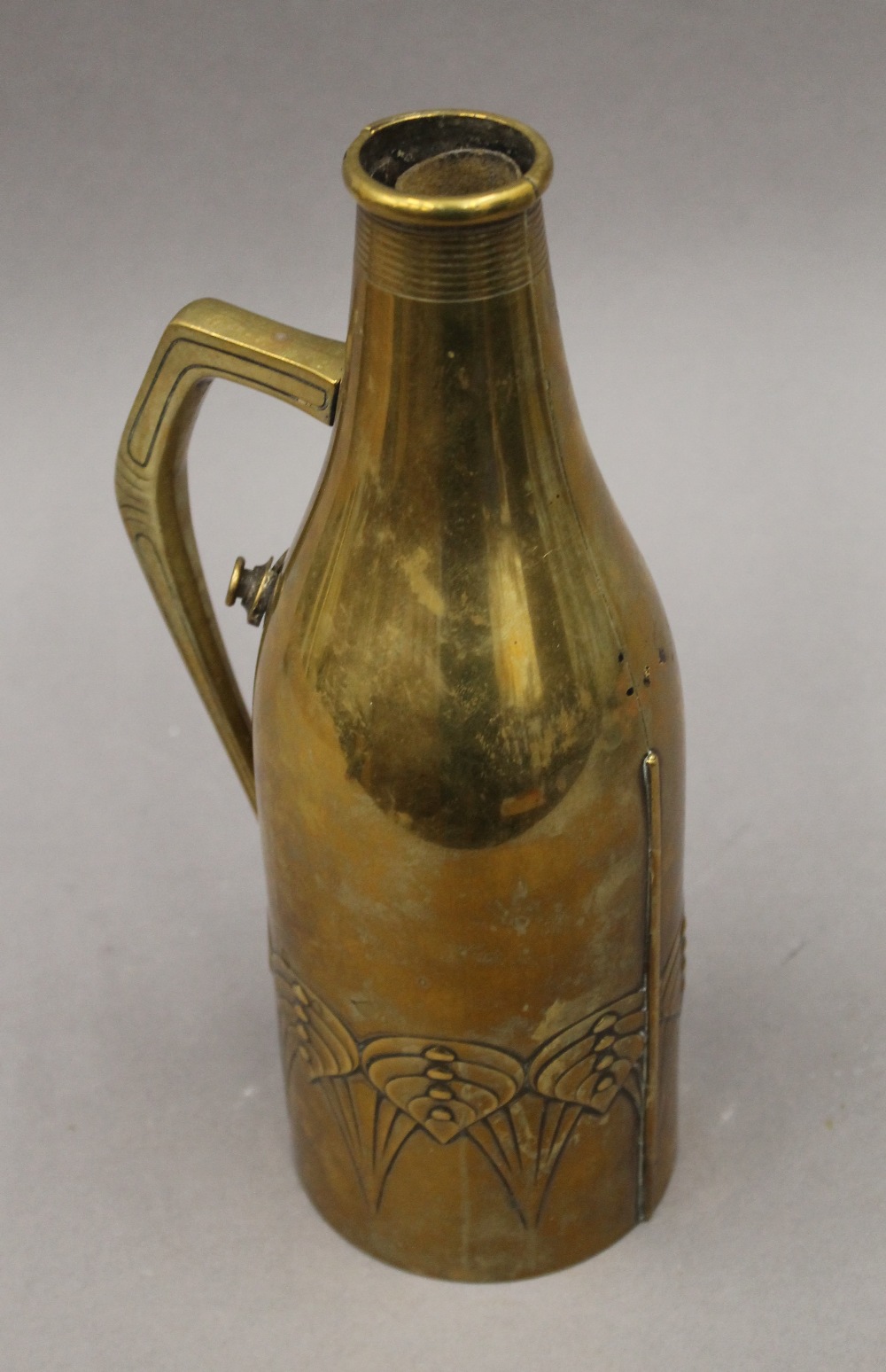 A W.M.F Arts and Crafts brass bottle cover. 29 cm high.