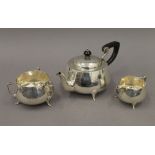An Arts & Crafts beaten silver three-piece tea set. The teapot 25 cm long. 23.