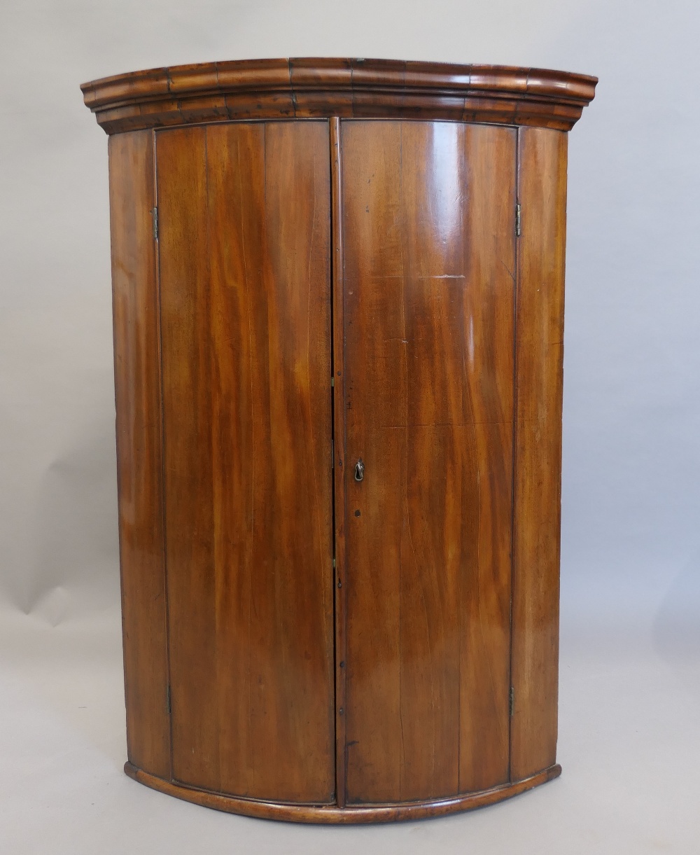 A George III mahogany bow front corner cupboard. 99 cm high.