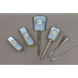 A six piece sterling silver and enamel brush set. The mirror 37.5 cm long.
