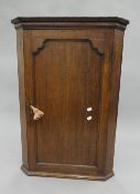 A Georgian oak hanging corner cupboard. 88 cm high.