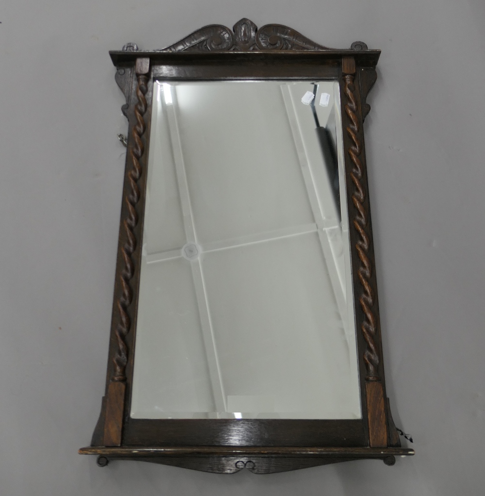 An early 20th century oak barley twist wall glass/mirror. 85 cm high.