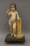 An antique polychromed painted carved wooden figure of a naked boy holding a peach,