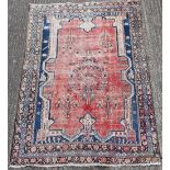 A red ground wool rug. 150 x 210 cm.