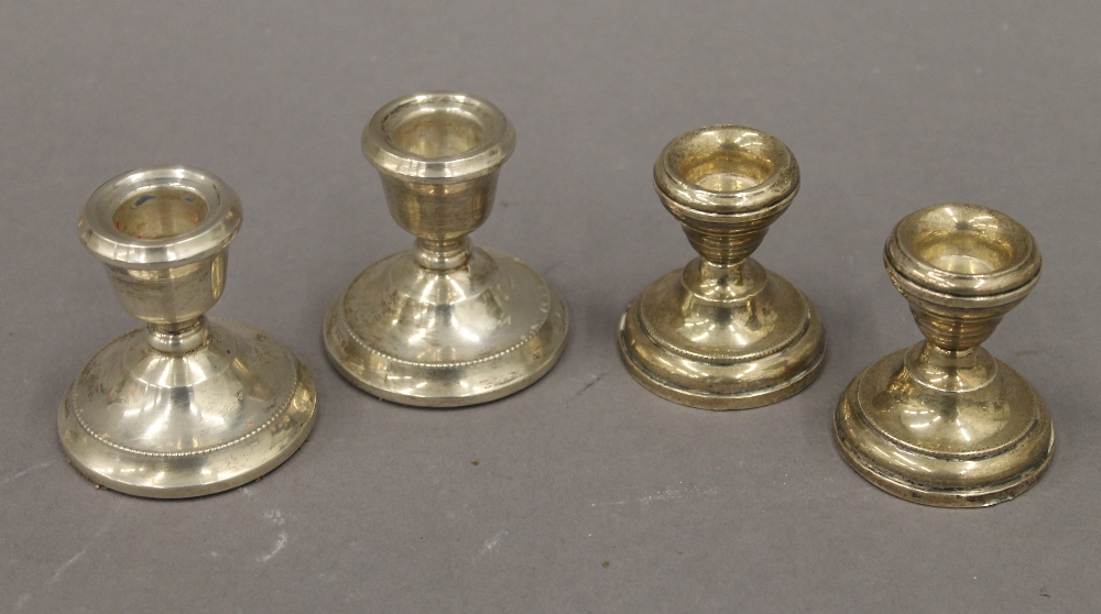 Two pairs of silver dwarf candlesticks. The largest 6.5 cm high. 11.2 troy ounces loaded.