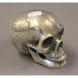 A silver plated skull. 9 cm high.