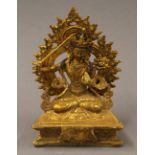 A gilt bronze model of Buddha holding a sword. 18 cm high.