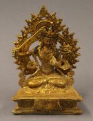 A gilt bronze model of Buddha holding a sword. 18 cm high.