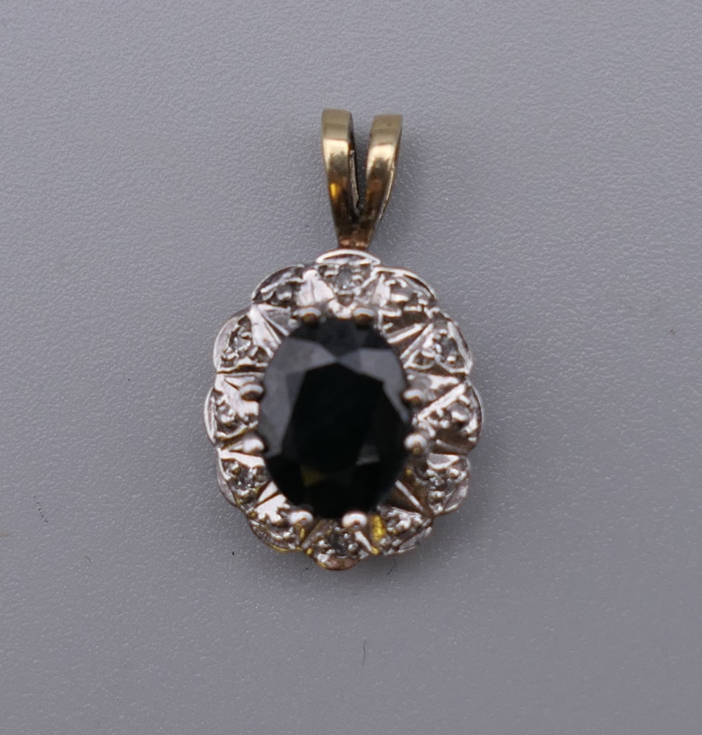 A 9 ct gold sapphire and diamond pendant. 1.75 cm high.