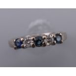 An 18 ct white gold diamond and sapphire five stone ring. Ring size K/L.