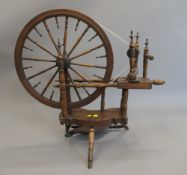 An antique spinning wheel. 94 cm wide.