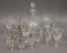 A quantity of small drinking glasses and a small decanter and stopper