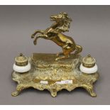 A porcelain mounted brass inkwell surmounted with a horse. 23.5 cm high.