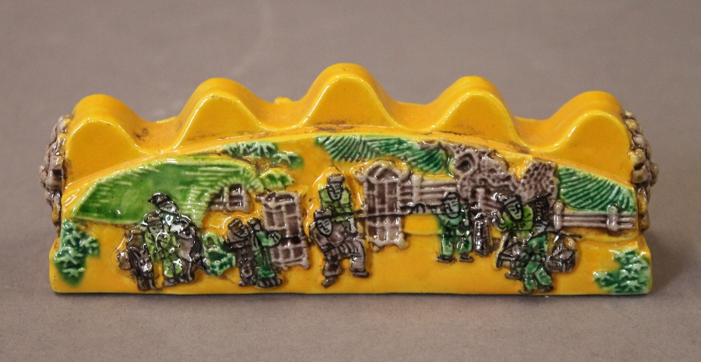 A Chinese yellow porcelain brush rest. 12.5 cm long.