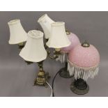 A pair of table lamps and another.