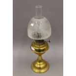 A Victorian brass oil lamp with etched glass shade. 60 cm high.