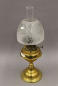 A Victorian brass oil lamp with etched glass shade. 60 cm high.