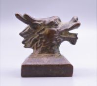 A bronze dragon mask seal. 4 cm high.