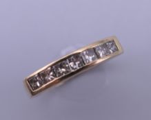 An 18 ct gold seven stone diamond ring. Ring size O.