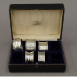 A box containing five various silver napkin rings. 3.1 troy ounces.