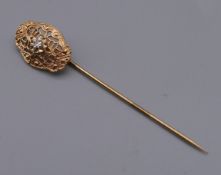 A vintage unmarked gold and diamond stick pin in a box. 5 cm high.