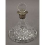 A silver collared cut glass ships decanter. 16 cm high.