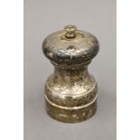 A silver pepper grinder. 10 cm high.