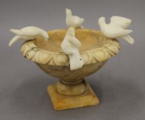 A 19th century alabaster model of doves on an urn, together with a 19th century alabaster plinth.