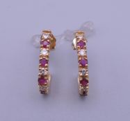 A pair of 14 K gold ruby and diamond ear studs.