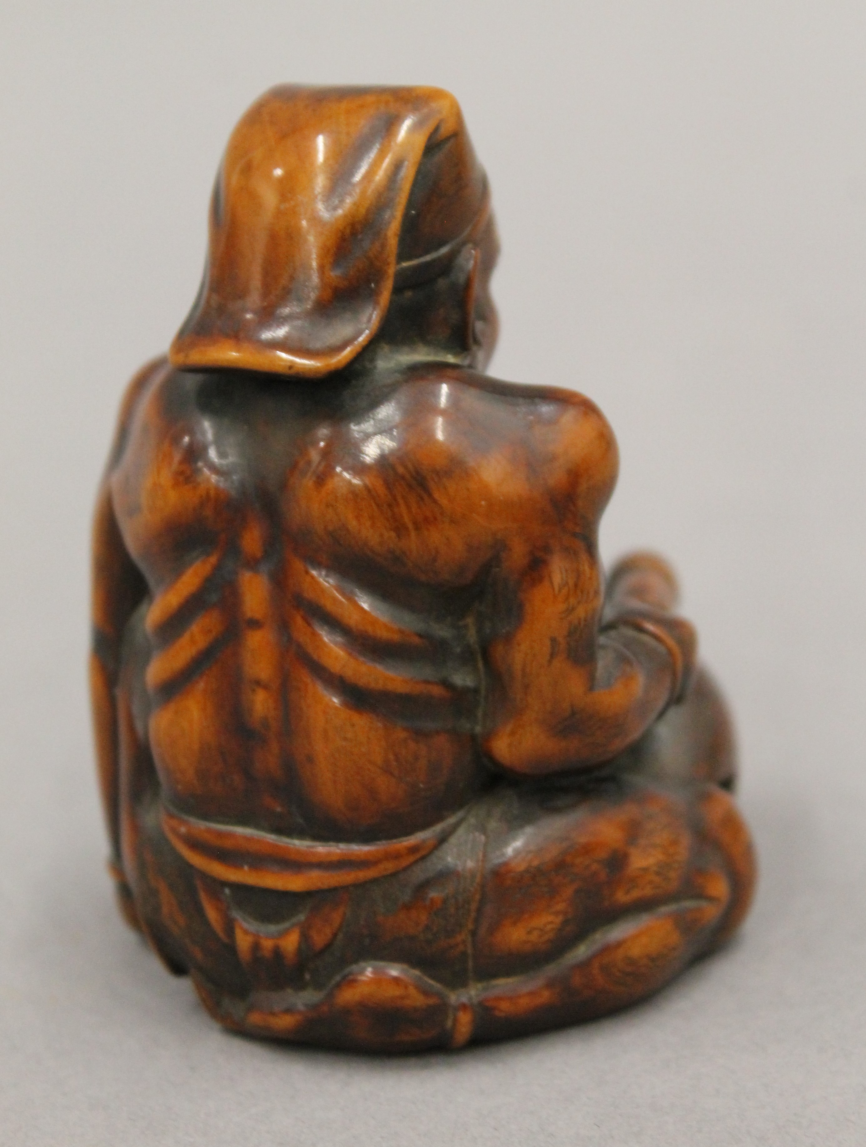 A boxwood okimono formed as a figure banging a drum. 7.5 cm high. - Image 3 of 5